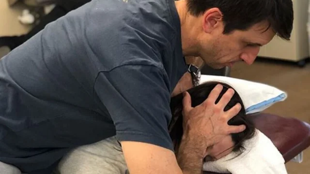 SporTherapy Therapist performs neck adjustment on patient.